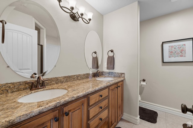 bathroom with a sink, tile patterned floors, double vanity, and baseboards