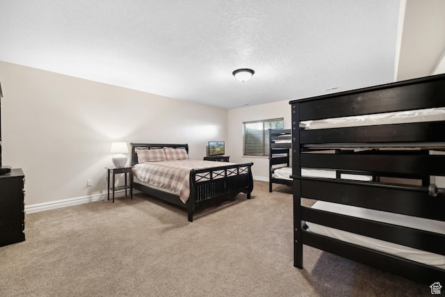bedroom with baseboards, carpet flooring, and a textured ceiling