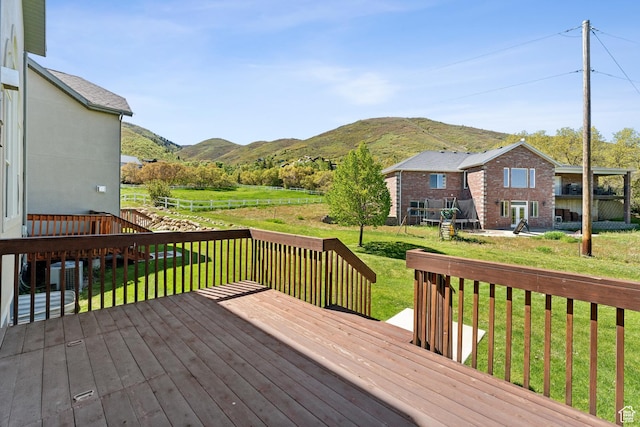 wooden terrace with a mountain view and a lawn