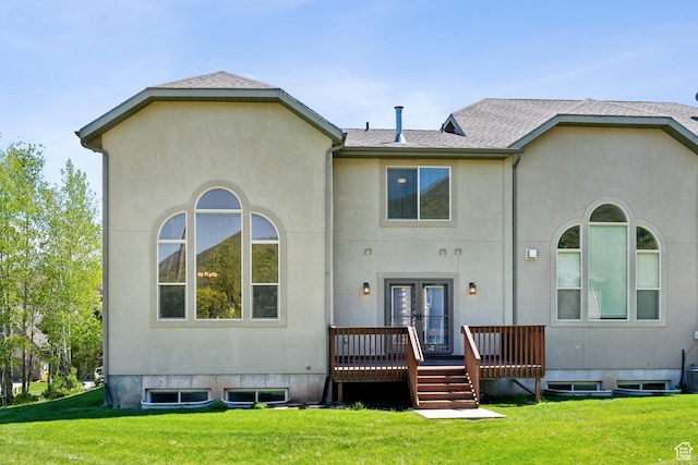 back of house featuring a yard, stucco siding, french doors, a shingled roof, and a deck