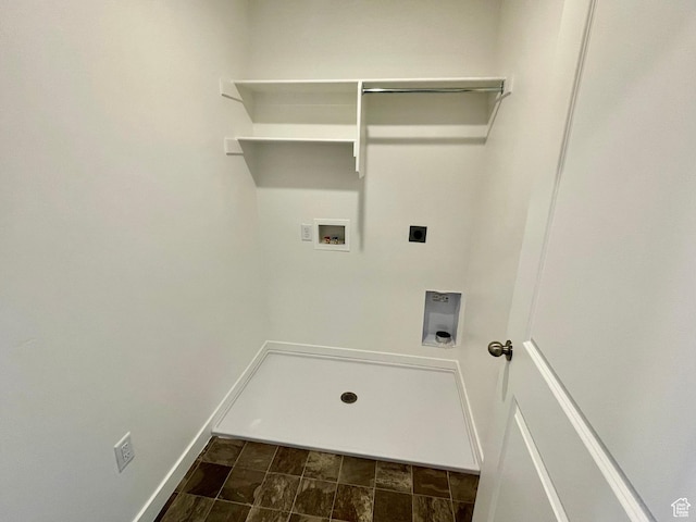 laundry area with laundry area, hookup for a washing machine, stone finish floor, hookup for an electric dryer, and baseboards