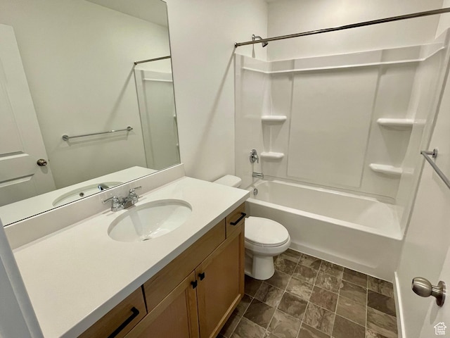 bathroom with toilet, shower / tub combination, stone finish floor, and vanity
