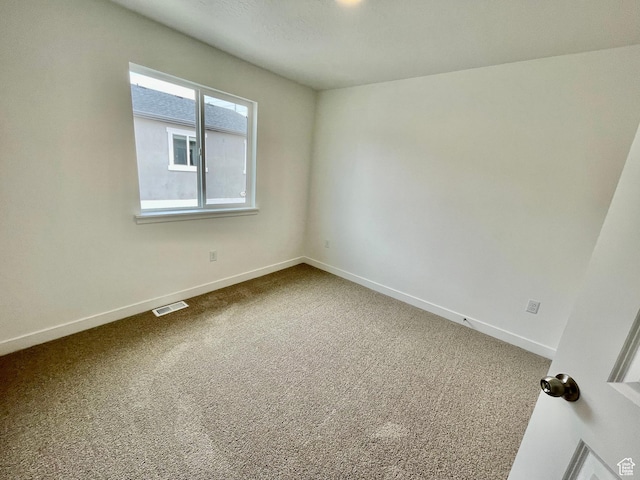 empty room with visible vents, baseboards, and carpet