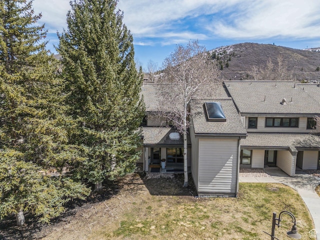 1450 Deer Valley Dr N, Park City, UT 84060 - back of property featuring a mountain view, a shingled roof, and a lawn