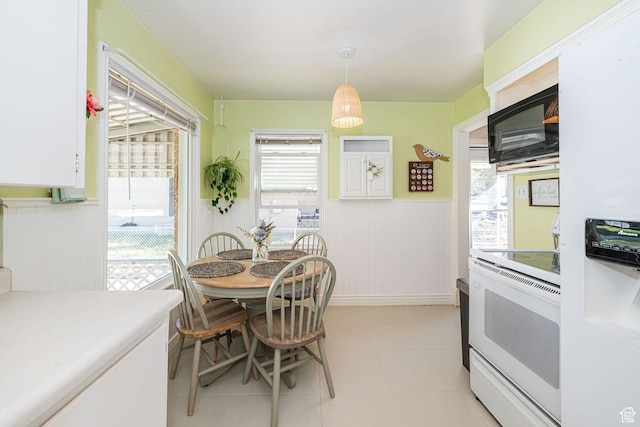 dining space with a wainscoted wall and plenty of natural light
