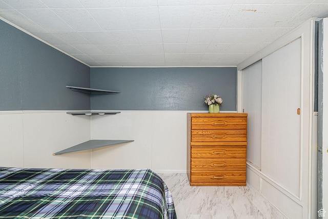 bedroom with a closet and wainscoting
