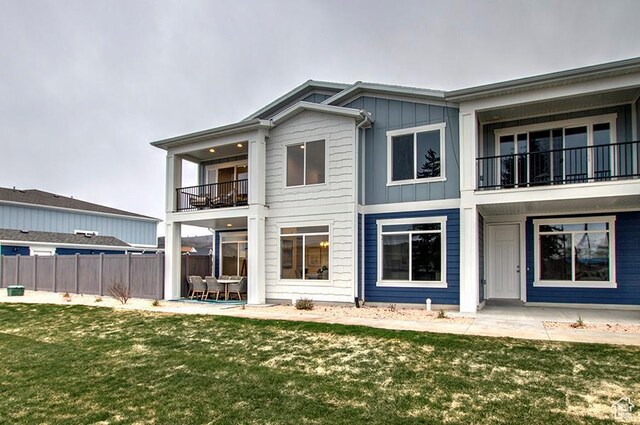 55 E Buttercup Ln Unit 42, Garden City, UT 84028 - rear view of house with a patio, a balcony, board and batten siding, a yard, and fence