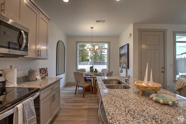 55 E Buttercup Ln Unit 42, Garden City, UT 84028 - kitchen with visible vents, range with electric cooktop, a notable chandelier, a sink, and stainless steel microwave