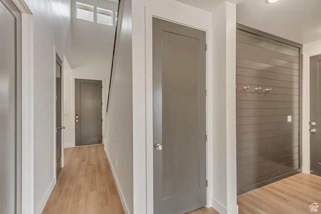 hall featuring light wood-type flooring, baseboards, and visible vents