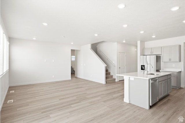 1345 N Harper Way Unit 0250, Tooele, UT 84074 - kitchen with gray cabinets, appliances with stainless steel finishes, recessed lighting, light wood-style flooring, and open floor plan