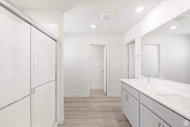 1345 N Harper Way Unit 0250, Tooele, UT 84074 - bathroom with a stall shower, wood finished floors, double vanity, and recessed lighting