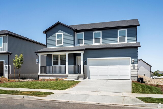 1345 N Harper Way Unit 0250, Tooele, UT 84074 - traditional-style home with a porch, concrete driveway, a garage, and a front lawn