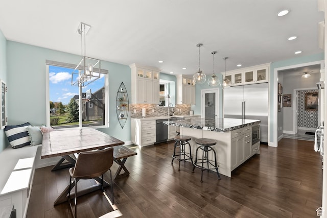 2154 E 1340 S, Heber City, UT 84032 - kitchen featuring glass insert cabinets, a center island, built in appliances, a breakfast bar area, and backsplash