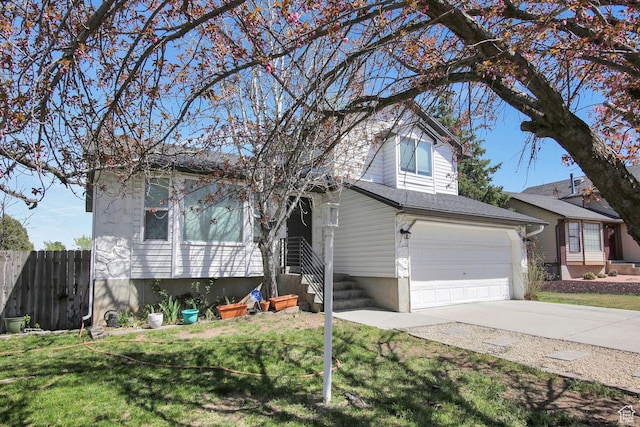 view of front of property featuring entry steps, fence, a front lawn, an attached garage, and concrete driveway
