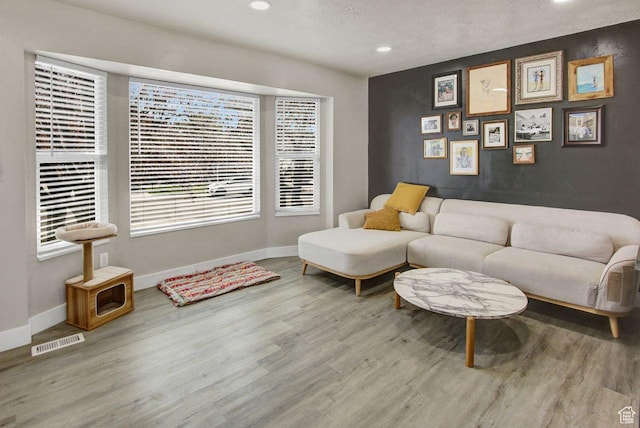living room with wood finished floors, baseboards, visible vents, and recessed lighting