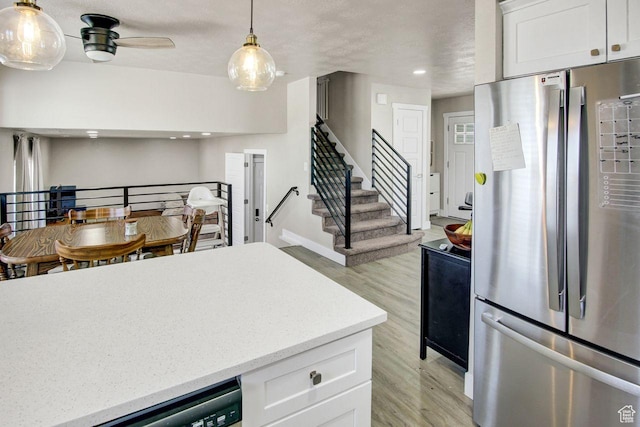 kitchen featuring freestanding refrigerator, white cabinetry, recessed lighting, light wood finished floors, and pendant lighting