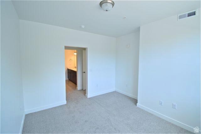 unfurnished room featuring carpet, visible vents, and baseboards