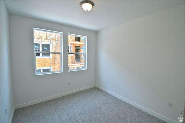 spare room with baseboards and carpet