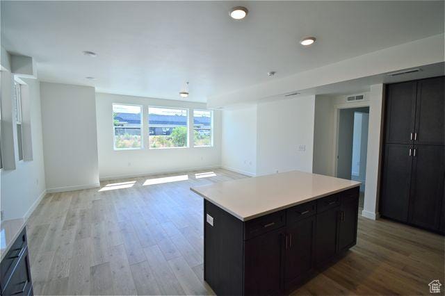 kitchen featuring open floor plan, light wood finished floors, light countertops, and visible vents
