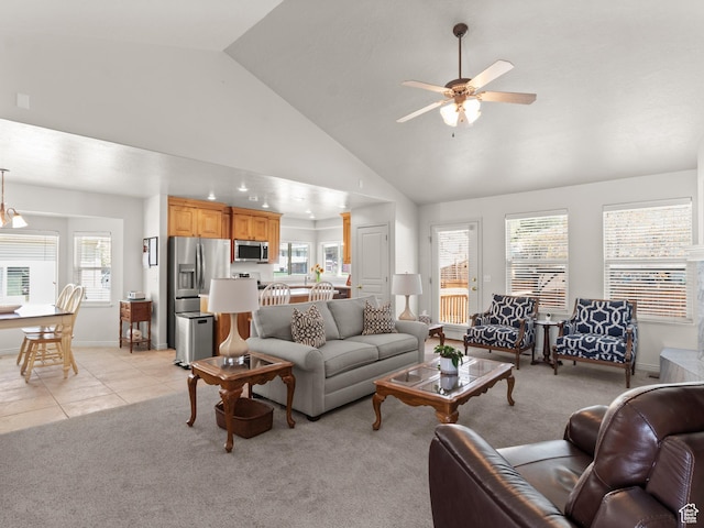 living room with ceiling fan, high vaulted ceiling, light carpet, and baseboards