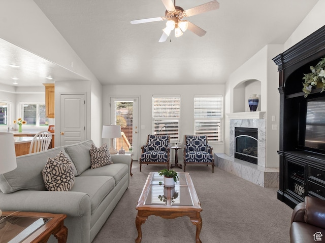 living area featuring carpet flooring, a high end fireplace, and vaulted ceiling