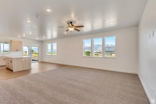 1162 W 3410 S, Nibley, UT 84321 - unfurnished living room featuring light wood-style flooring, baseboards, a ceiling fan, and recessed lighting