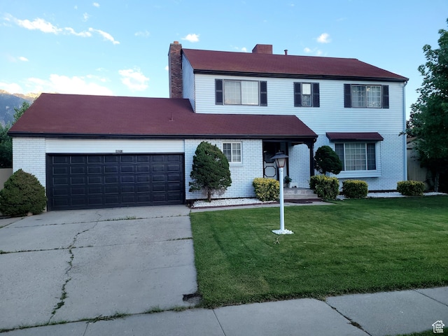 view of front facade featuring concrete driveway, a chimney, an attached garage, a front lawn, and brick siding