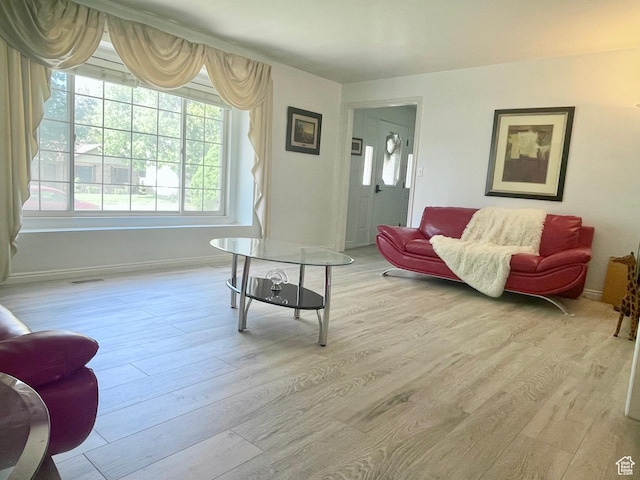 living room with visible vents, baseboards, and wood finished floors