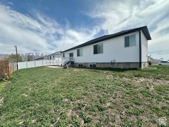 122 W 930 S, Tremonton, UT 84337 - rear view of house featuring a yard, a mountain view, and fence