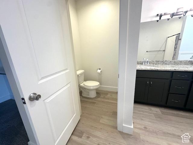 122 W 930 S, Tremonton, UT 84337 - full bathroom featuring toilet, wood finished floors, vanity, and baseboards