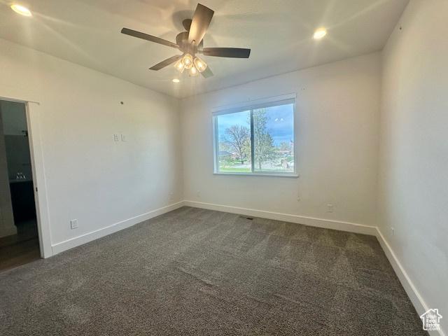 122 W 930 S, Tremonton, UT 84337 - spare room featuring dark colored carpet, a ceiling fan, and baseboards