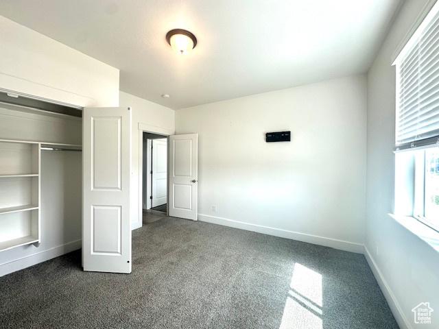 122 W 930 S, Tremonton, UT 84337 - unfurnished bedroom with dark carpet, baseboards, and a closet