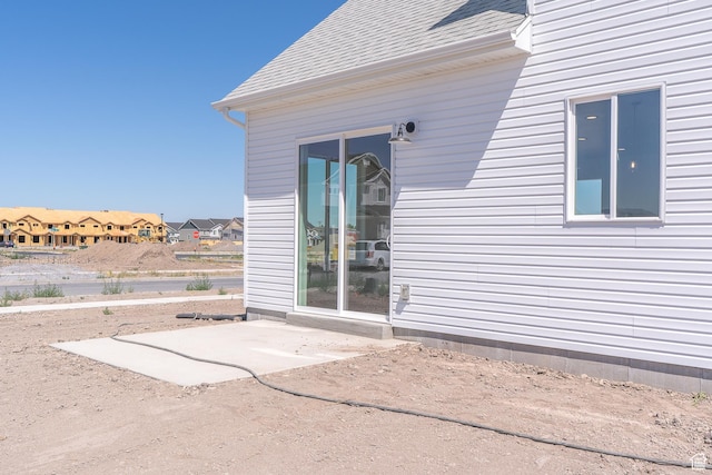 1038 W 2260 S Unit 105, Nibley, UT 84321 - entrance to property with a patio area, roof with shingles, and a residential view