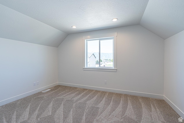 1038 W 2260 S Unit 105, Nibley, UT 84321 - additional living space featuring vaulted ceiling, carpet floors, and a textured ceiling