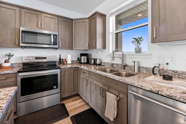 25 E Center Unit 10, North Salt Lake, UT 84054 - kitchen featuring a sink, light wood-type flooring, appliances with stainless steel finishes, and light stone countertops