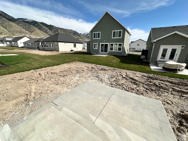 back of house with french doors, a yard, a mountain view, and a residential view