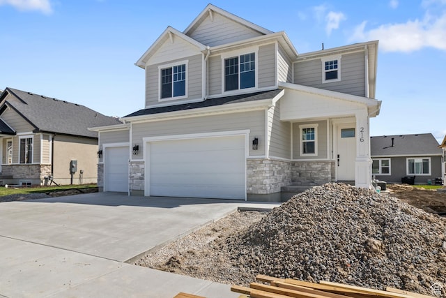 view of front of house with driveway, an attached garage, and stone siding