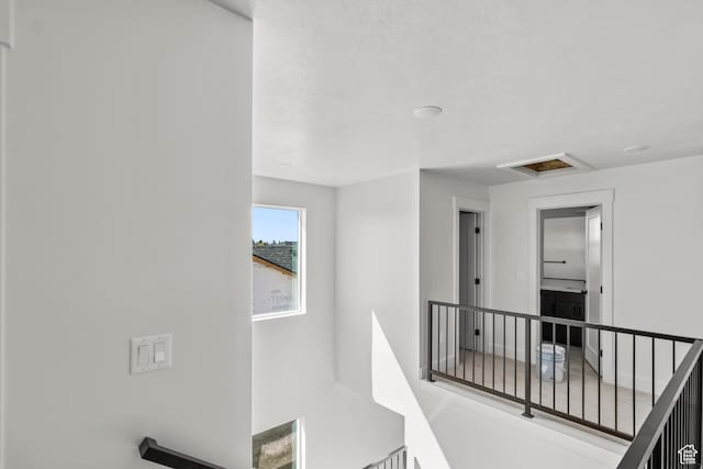 hall featuring an upstairs landing and attic access