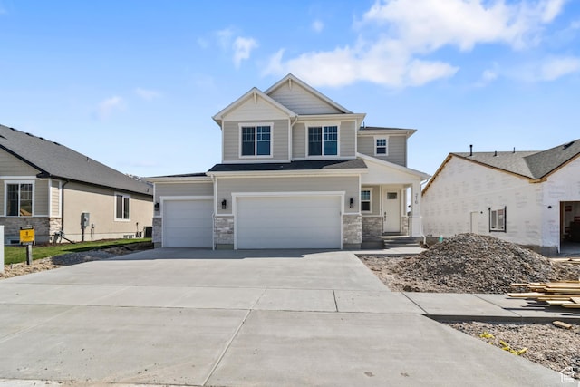 craftsman-style home featuring concrete driveway, stone siding, and a garage