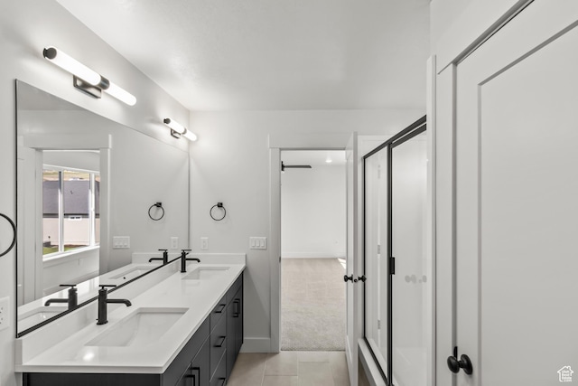 bathroom with a stall shower, tile patterned flooring, a sink, and double vanity