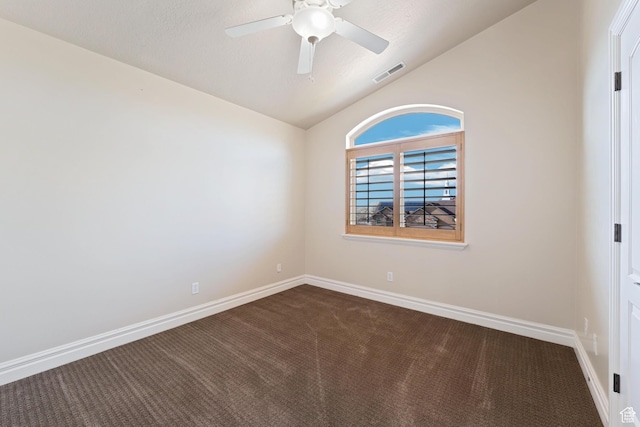 unfurnished room with dark carpet, ceiling fan, vaulted ceiling, and visible vents