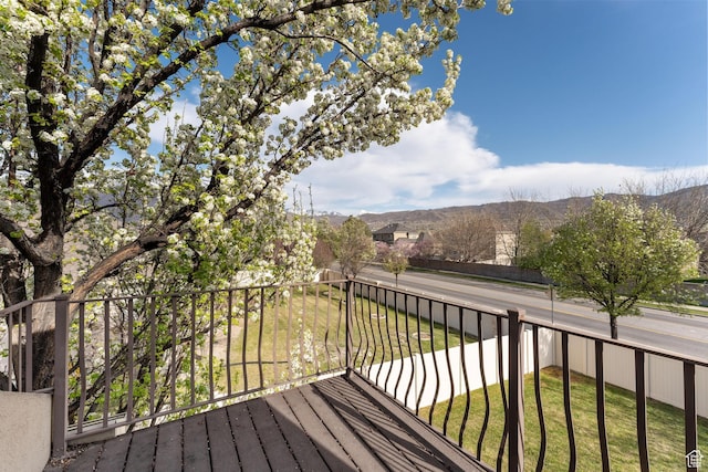 wooden terrace featuring a yard and a mountain view