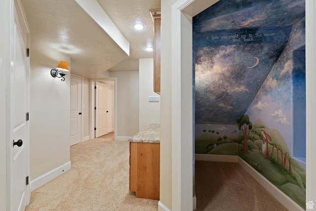 corridor with baseboards, carpet, and a textured ceiling