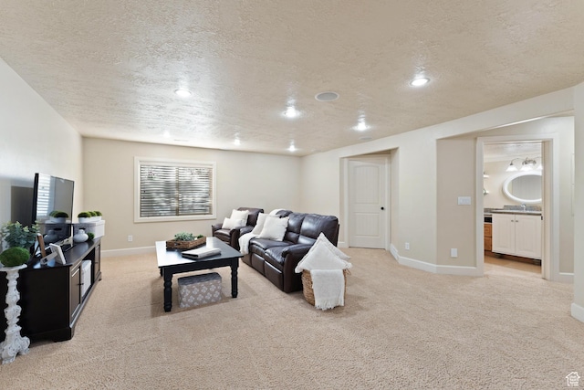 living area featuring recessed lighting, light carpet, a textured ceiling, and baseboards