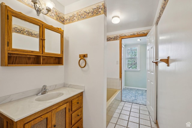 full bathroom with a bathing tub, tile patterned floors, vanity, and baseboards