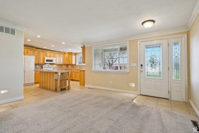 entrance foyer with light tile patterned floors, baseboards, ornamental molding, and visible vents