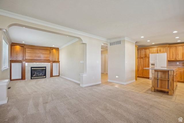 unfurnished living room featuring baseboards, ornamental molding, recessed lighting, visible vents, and arched walkways
