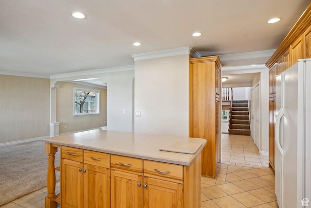 kitchen with crown molding, freestanding refrigerator, recessed lighting, light tile patterned flooring, and light countertops