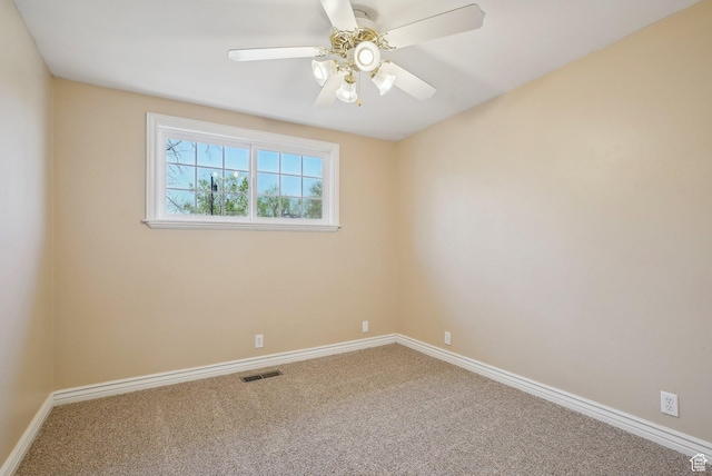 empty room featuring carpet floors, baseboards, a ceiling fan, and visible vents