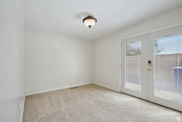 carpeted spare room with french doors, baseboards, and visible vents